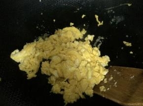 锅内放入适量油，把鸡蛋放入锅内翻炒成快状。