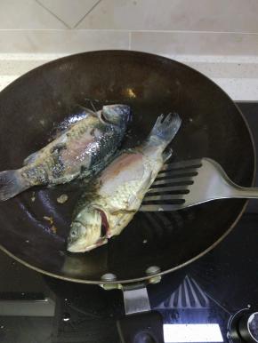 锅内放热油,把鱼两面的水用吸油纸擦干净,放入油锅内两面煎到微黄