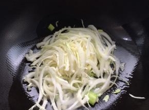 锅内放入适量油，放入葱。把白菜放入锅内翻炒一分钟左右。