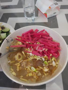 切好的还凉粉放入碗内。在萝卜上加入醋和白糖，凉粉上放入葱花，蒜末、盐进行调味