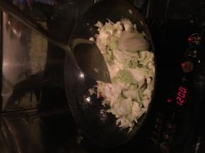 把白菜放进锅里翻炒，适量加入味达美。