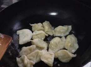 锅内放入适量的油加热，把水饺放入锅中
