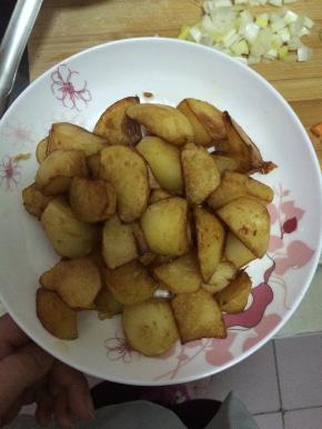 炸好的土豆捞出放入盘子中