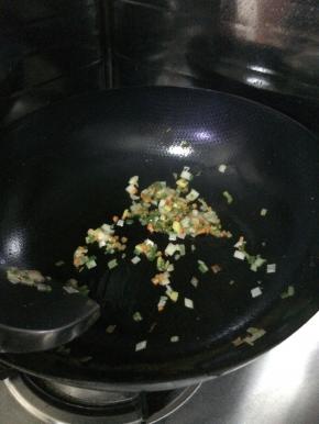 把炸好的土豆放入锅内，加入适量的葱花。
