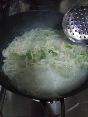 锅内加入适量的水烧开，把金针菇和青椒放入水中焯一下。