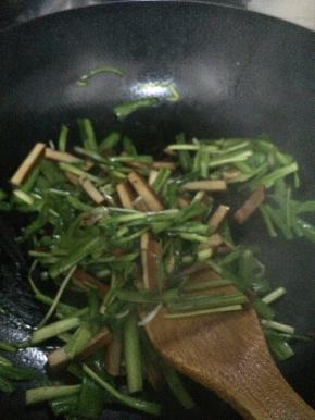 锅内放入适量油，把韭菜放入锅中翻炒一分钟左右，把豆腐干放入锅内。