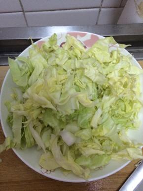 卷心菜切成丝状，放入盘子中。