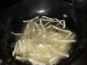 把薯条放入锅内，炸至微黄。捞出
