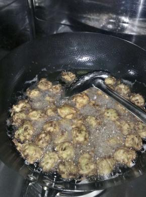 锅内倒入适量的油，大火将油烧开，带上一次性手套，做成丸子状，放入锅内炸。