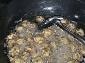 锅内倒入适量的油，大火将油烧开，带上一次性手套，做成丸子状，放入锅内炸。