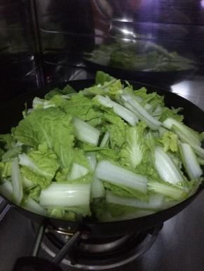 锅内放入食用油葱，把小白菜放入锅内翻炒，
