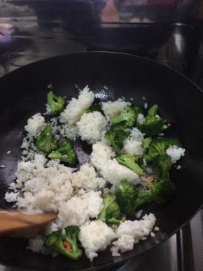 锅内放入适量油，放入葱。先把西兰花放入锅中炒8分熟，然后加入米饭