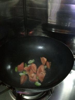 锅内放入适量油，把西红柿放入锅内炒一分钟，加入适量的水。