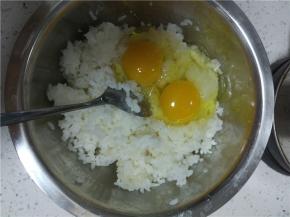 压散的米饭中，打入两个鸡蛋，最好的是只用蛋黄，不用蛋清，炒出来的颜色会特别的黄，这里比较懒直接放了两个整蛋