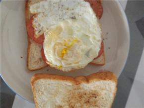 一层面包，上面铺满火腿，放上煎熟的鸡蛋，放上另外一层面包，可以用牙签固定之后，切小块