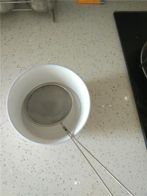 煮好的西米用漏勺捞出，放入酒酿里面