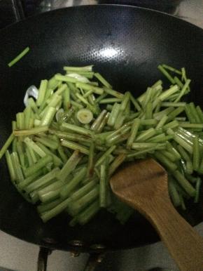 锅内加入适量油，把山芹放入锅内翻炒两分钟左右。