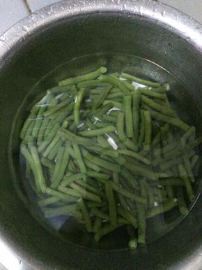 把芸豆摘好，清洗干净，把芸豆切成段状。水烧开之后，把切好的芸豆放入水中，煮3分钟左右，捞出。