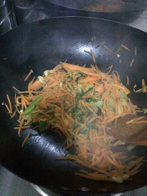 随后放入胡萝卜丝小火炒。