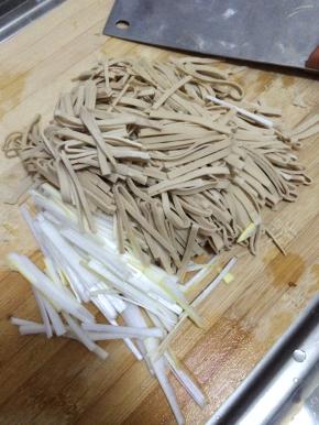 把豆腐皮清洗干净切成长条状，葱洗干净切成条状