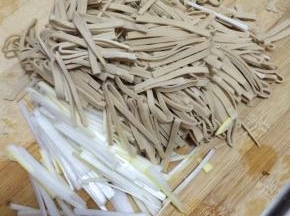 把豆腐皮清洗干净切成长条状，葱洗干净切成条状