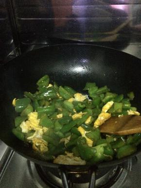 青椒放入锅中炒，放入适量盐和味达美。翻炒三分钟左右，把鸡蛋加入锅中翻炒。