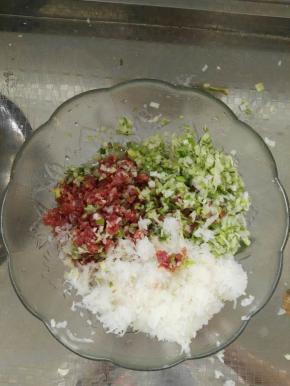 把准备好的白萝卜、葱、姜、肉都剁成碎状。放入盆中。