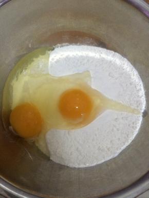 把面粉放入盆中，鸡蛋打入盆中。