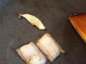 起锅放一点油，下入五花肉片和姜片小火煸至肉片透明，边缘略焦。