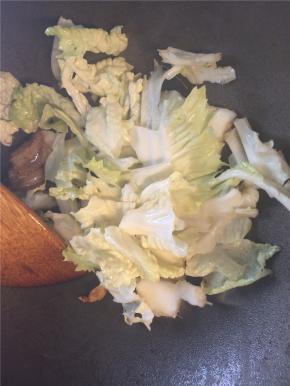 转大火下入白菜翻炒两分钟，加入足量热水
