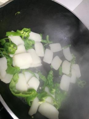 依次加入少量水、适量鲜酱油、盐、搅拌均匀，翻炒5分钟左右，使得年糕软糯