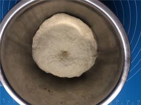 取出发酵好的面团，加少许干面粉揉面排气后，擀成约8寸大的圆片，放温暖处二次发酵约10分钟