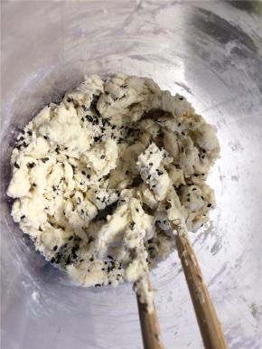 用剩的已打发奶油中，加入面粉和黑芝麻，用筷子搅拌成絮状