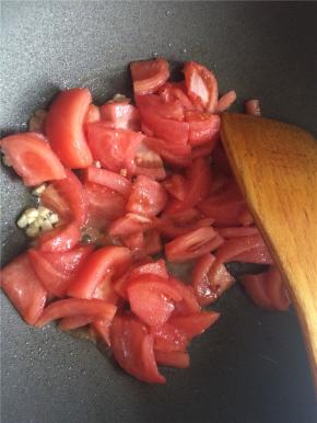 炒锅热油爆香蒜片，下入番茄块翻炒