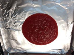 取烤盘铺上锡纸，将熬好的果泥倒在锡纸上