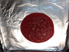 取烤盘铺上锡纸，将熬好的果泥倒在锡纸上