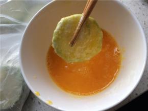 鸡蛋加盐打散，裹好面粉的西葫芦片放入蛋液中均匀地裹上蛋液