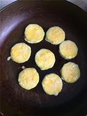 平底锅刷一层油，油热后下入裹好蛋液的西葫芦片，小火煎至底面金黄