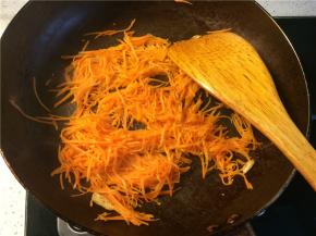 下入胡萝卜丝，加少许盐翻炒至熟透变软