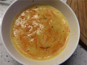 将炒熟的胡萝卜丝晾凉后加入蛋液，搅拌均匀