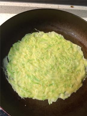 平底锅刷薄油烧热后转小火，倒入一勺面糊，迅速转动锅子使面糊均匀平铺，不均匀的地方也可用铲子刮平，使西葫芦丝均匀分布在整张饼上