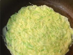 平底锅刷薄油烧热后转小火，倒入一勺面糊，迅速转动锅子使面糊均匀平铺，不均匀的地方也可用铲子刮平，使西葫芦丝均匀分布在整张饼上