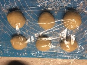 将排气好的面团分成6等分，滚圆后盖上保鲜膜松弛10分钟