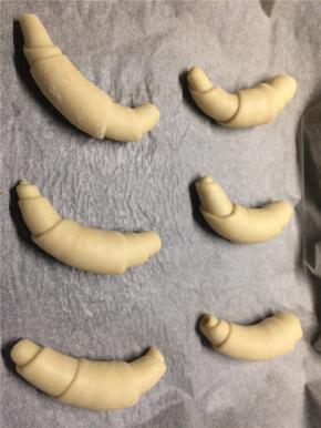 从宽的一头轻轻卷起成面包卷，卷好的末端向下放入烤盘，盖上保鲜膜再次发酵约30分钟至两倍大