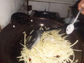 翻入土豆丝，大火翻炒，出锅前加入适盐，出锅入盘。