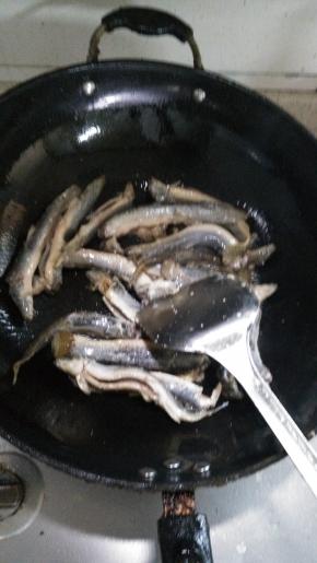 在锅内倒入适量的花生油，倒入泥鳅，翻炒