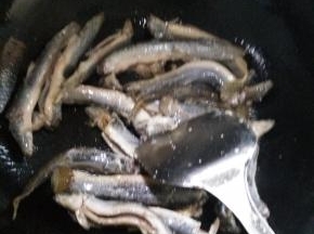 在锅内倒入适量的花生油，倒入泥鳅，翻炒