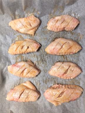 腌好的鸡翅放在铺有油纸的烤盘上，放入预热180度的烤箱，中层，30分钟