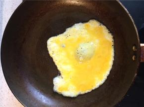 锅内倒入比平时炒鸡蛋略多一点的油，油热后倒入打散的鸡蛋，待蛋液凝固用筷子划散炒成蛋花