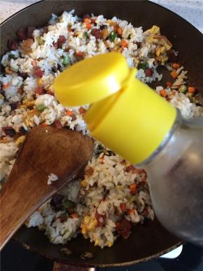 倒入酱油，翻炒均匀，使每粒米饭都裹上酱油色